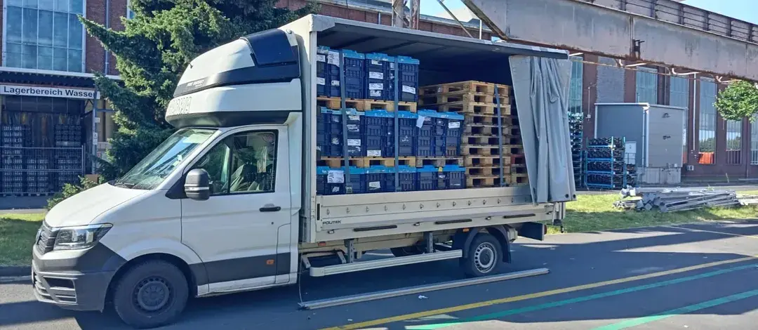 Utovaren kombi — gajbe i palete spremne za isporuku